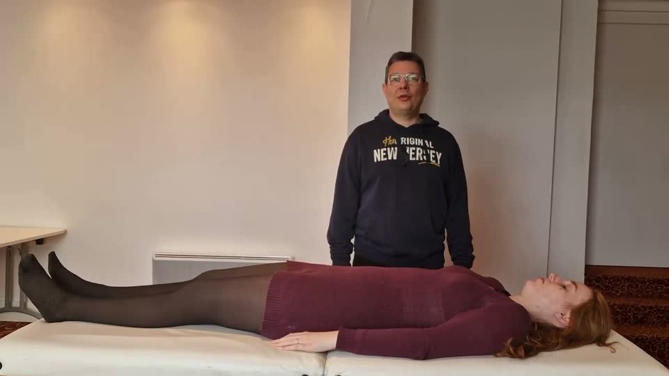 Praticien debout aux pieds du receveur, posture ancrée
