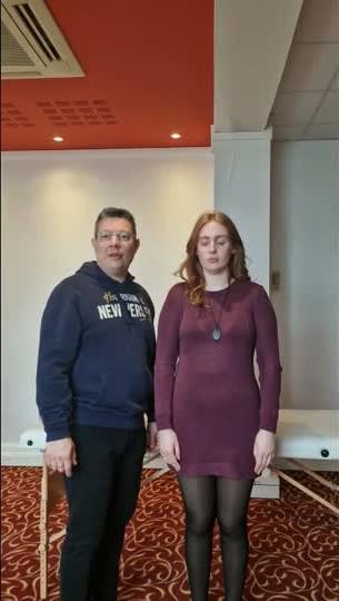 Praticien et receveuse debout, face à face, posture calme avant le geste