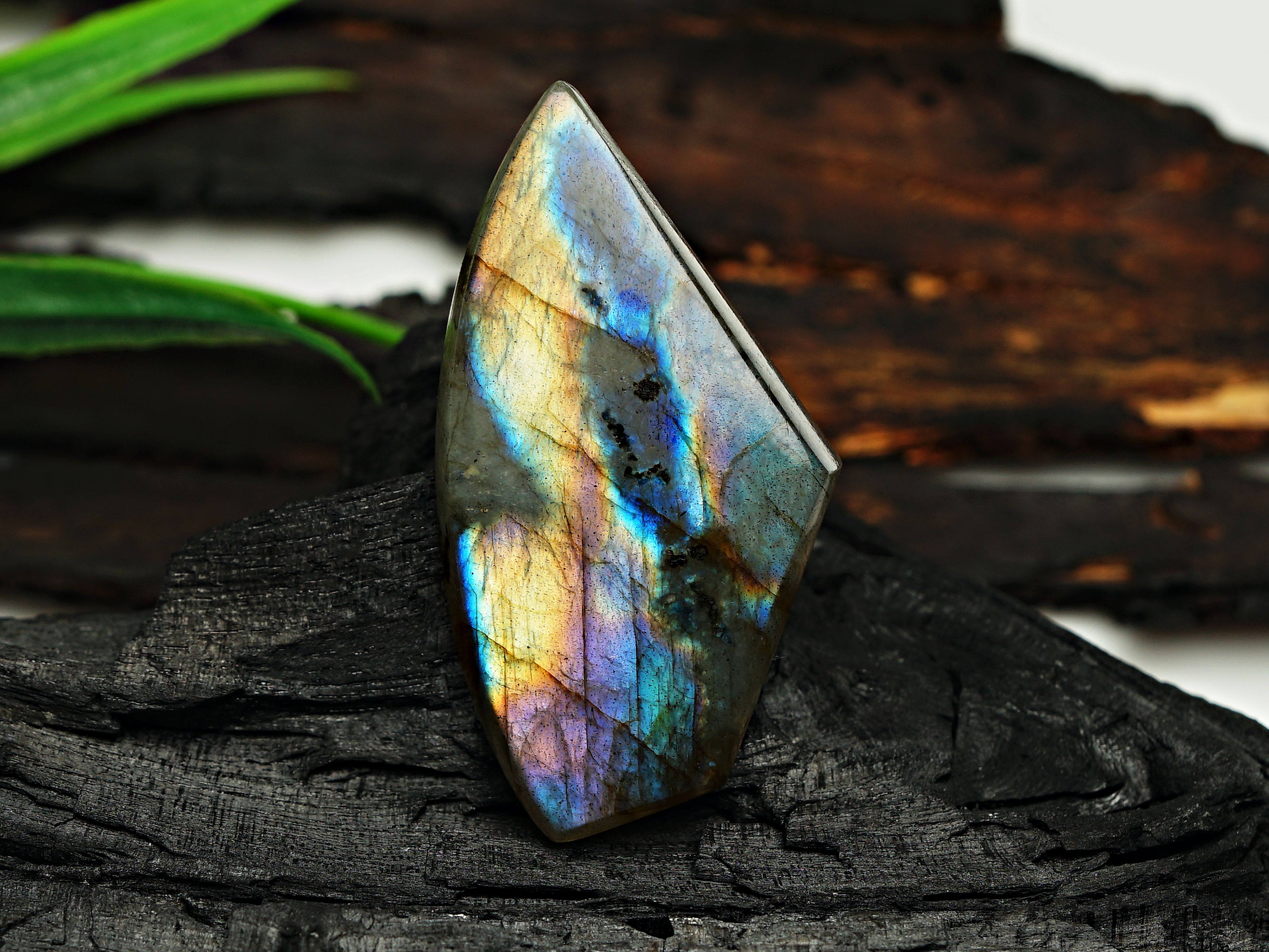 Pierre de labradorite grise laissant apparaître son reflet chatoyant bleu-vert caractéristique (labradorescence)