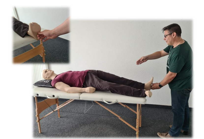 Praticien aux pieds du receveur allongé, avec gros plan sur la prise de la main autour du pied